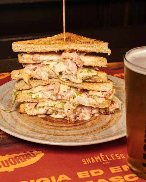 Club sandwich a tre strati dello Shameless Pub servito con birra